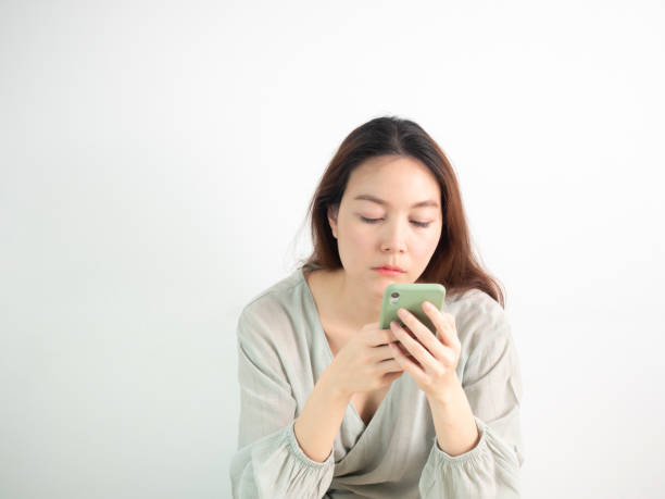 istock Asian Woman using mobile smart phone on white background. 1254442965