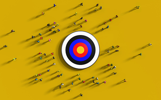 Human crowd gathering around a red bulls eye on yellow background. Easy to crop for all print and social media sizes horizontal composition with copy space. Marketing and target audience concept.