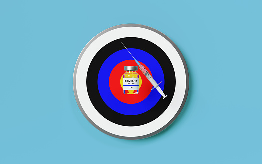 Covid-19 vaccine bottle and syringe on a colorful target on blue background. Covid-19 vaccine concept easy to crop for all print and social media sizes horizontal composition with copy space.