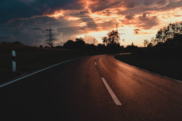 Empty Road under Dramatic colorful Sunset Sky Empty rural Country Road under moody dramatic Sunset Skyscape. Baden Württemberg, South Germany, Germany, Europe reutlingen photos stock pictures, royalty-free photos & images