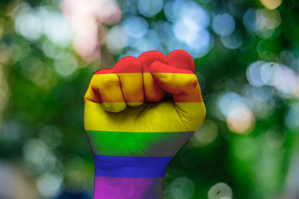 Pride lgbt concept. Fist raised with the lgbt flag asking for freedom and equality on a white background.