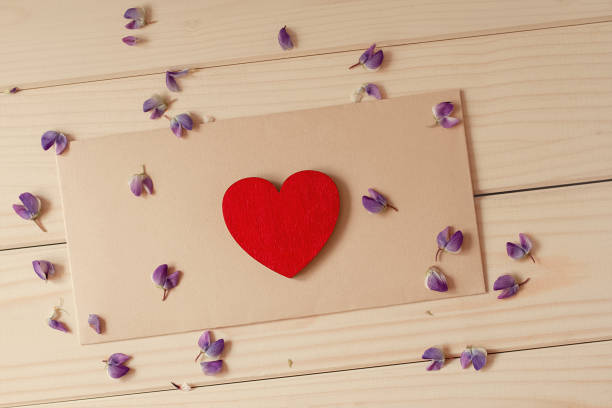 istock flat lay red wood heart lies on craft envelope on rustic table with scattered inflorescences of field lupine 1254451667