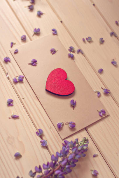 istock rustic postcard brown vintage envelope with craft red heart in perspective on wooden table with bouquet of flowers lupine diagonally 1254451669