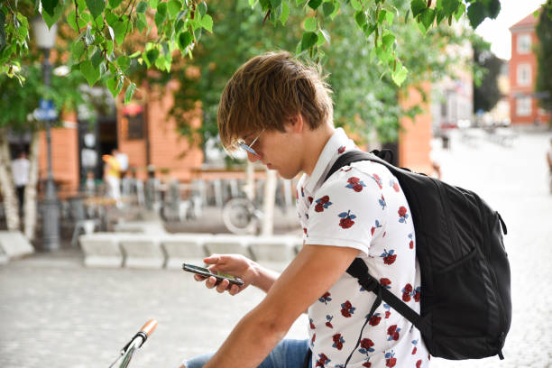 istock young adult man using smart phone and sitting on his bicycle 1254451741