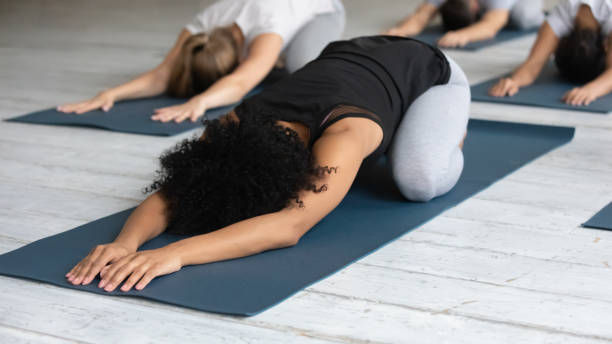 istock Young female african american instructor showing Child pose. 1254455281