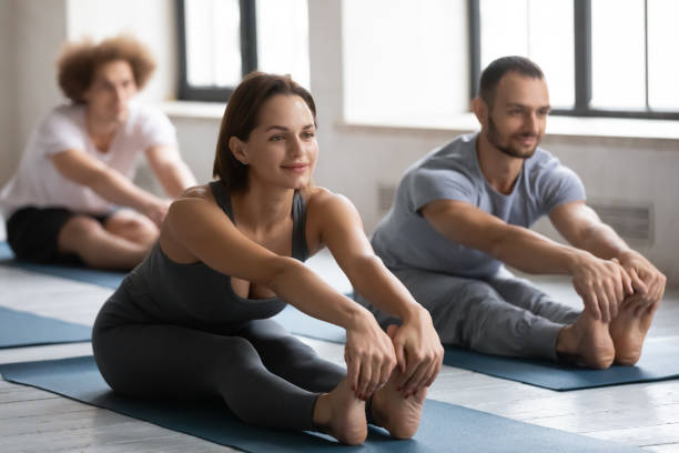 istock Happy woman stretching muscles in seated forward bend pose. 1254455299