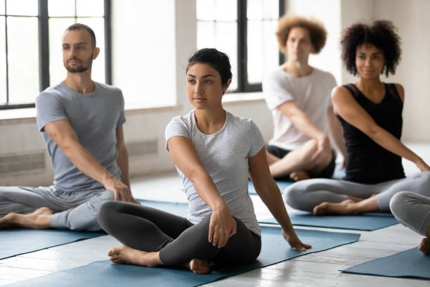 istock Young mixed race people doing simple seated twist exercise. 1254455337