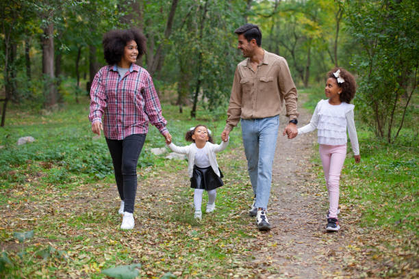 istock Happy family walking along a path in the woods 1254455343