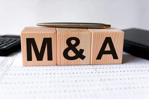 Photo of cubes with the word M&A on them. Care concept.