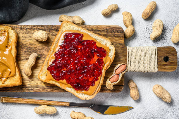 istock Peanut butter and jelly on white bread toasts.  White background. Top view 1254456490