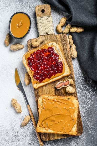 Peanut butter and jelly on white bread toasts.  White background. Top view