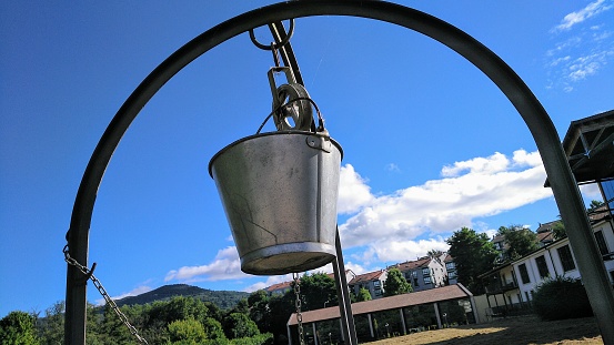 Well equipment on a field, clear sky in the background, close-up of pulley and bucket. Allariz village, Ourense province, Galicia, Spain.