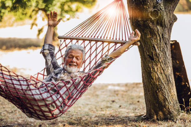 istock Caucasian Senior man lying on hammock in a pine forest. Outdoors relaxation. 1254458532