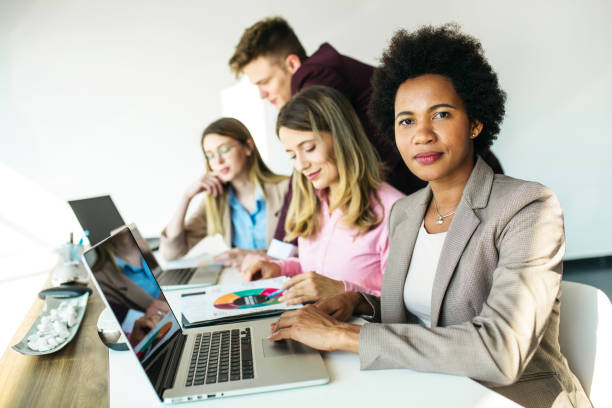 istock Group of businesspeople working on laptop computer and discussing 1254462507