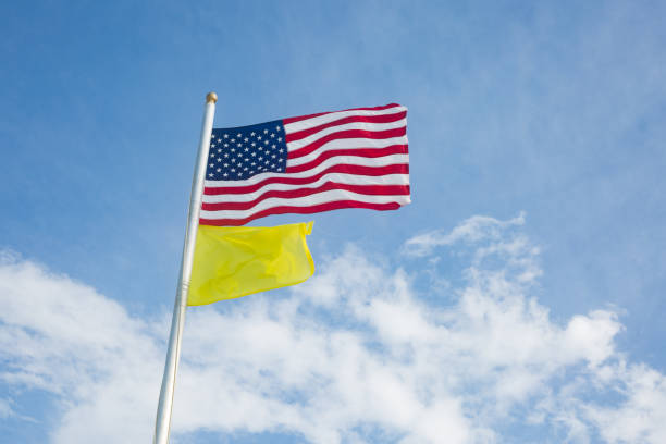 istock American Flag and Yellow Flag Flying at the Beach - Medium Hazard 1254462561