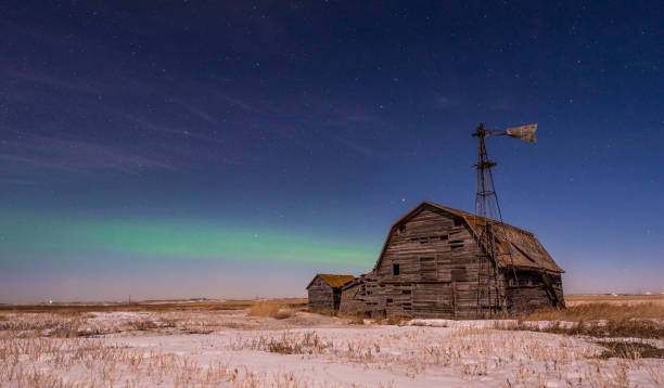 aurora borealis über einer verlassenen präriescheune - prairie farm winter snow stock-fotos und bilder