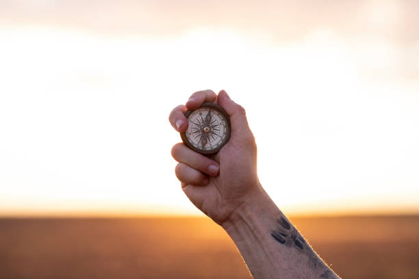 istock hand holds a compass in flower field 1254467488