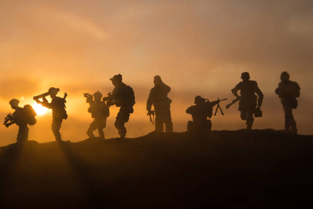 War Concept. Military silhouettes fighting scene on war fog sky background, World War Soldiers Silhouette Below Cloudy Skyline At sunset. War Concept. Military silhouettes fighting scene on war fog sky background, World War Soldiers Silhouette Below Cloudy Skyline sunset. Selective focus battlefield photos stock pictures, royalty-free photos & images