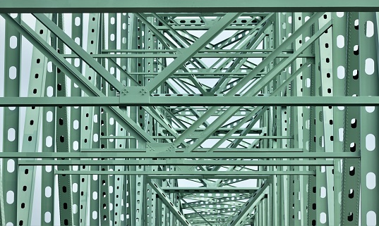 Green metal bridge structures.  Strong diagonal lines and geometric shapes.