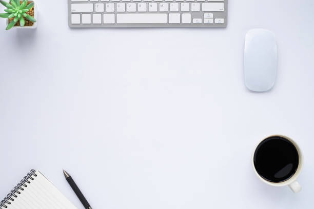 istock Top view above of White office desk table with keyboard, notebook and coffee cup with equipment other office supplies. Business and finance concept. Workplace, Flat lay with blank copy space. 1254481156