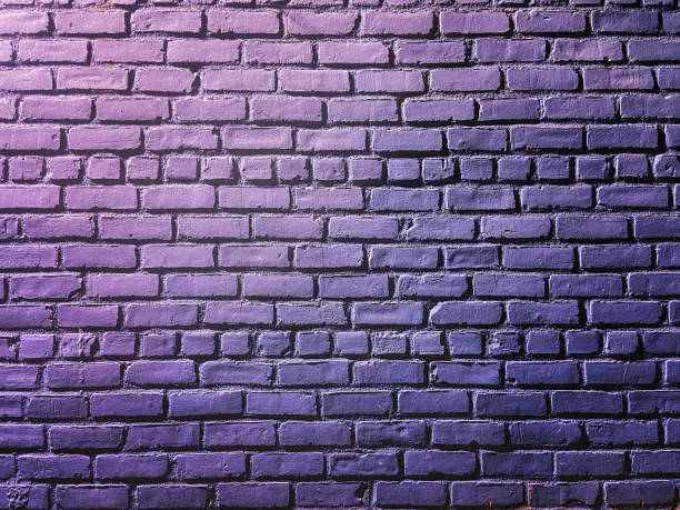istock Bare and empty exterior brick wall painted in lavander color 1254483363