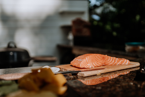 Man slicing salmon file for barbecue
