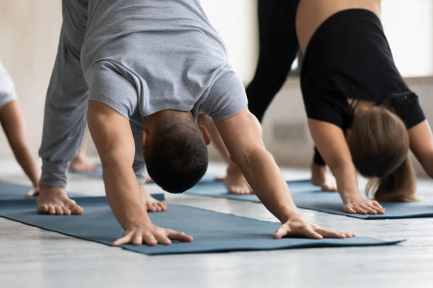 istock Young healthy strong man standing in downward facing dog pose. 1254486374