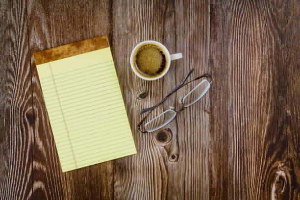 istock Business office supplies notebook with glasses and coffee on table 1254488944