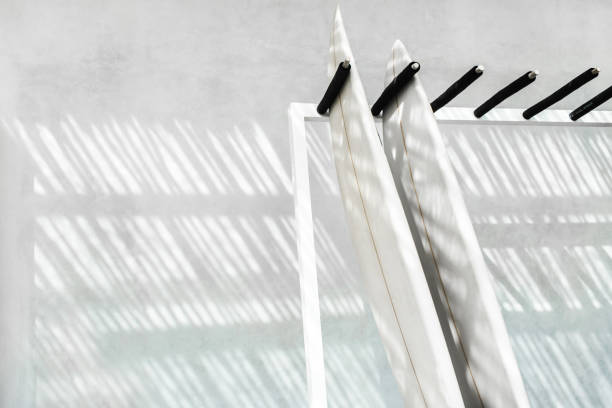 istock Rack with two surf boards on gray concrete background with beautiful day sun light. Active lifestyle, sports equipment.  Rent surfing board in Bali. 1254489749