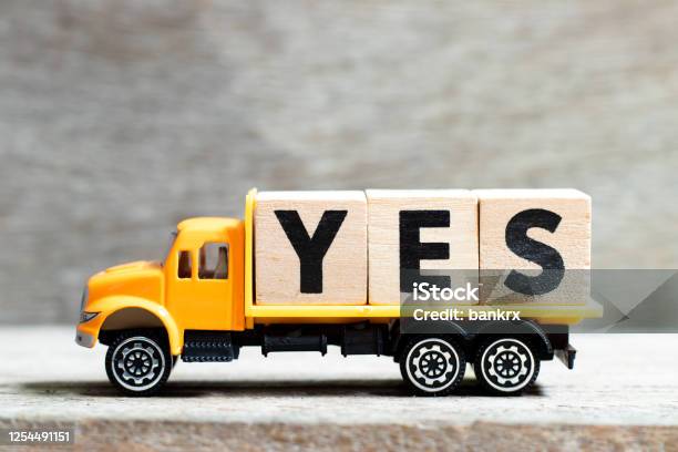 Truck Hold Letter Block In Word Yes On Wood Background Stock Photo - Download Image Now