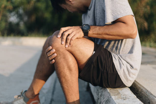 istock Close up young man hands  knee injury while exercise or running, 1254497212