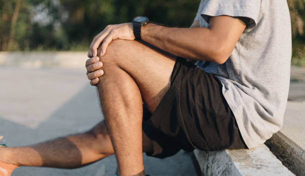 istock Close up young man hands  knee injury while exercise or running, 1254497244