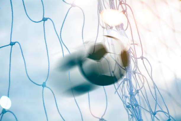 istock soccer ball in goal net with The light 1254498172