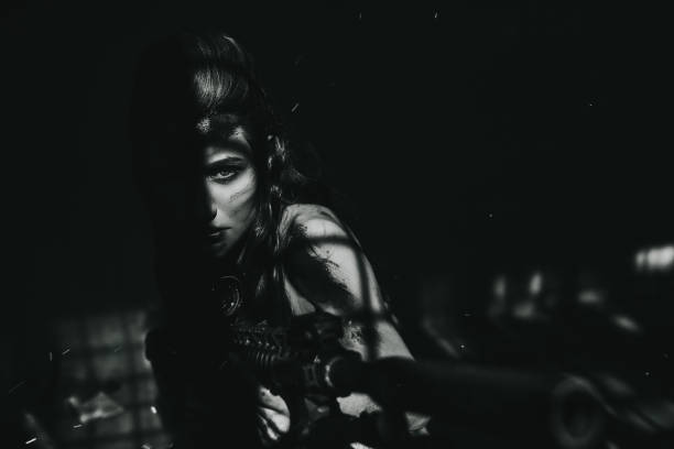 Courageous female warrior pointing gun at you Monochrome shot of angry female warrior holding large rifle, feeling courageous and aiming, looking at the camera female sharp shooter stock pictures, royalty-free photos & images