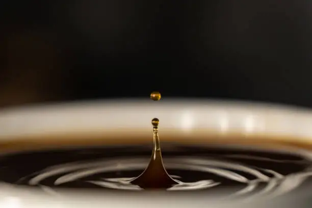 Photo of coffee splash and drop . macro close up brown liquid with smoke.