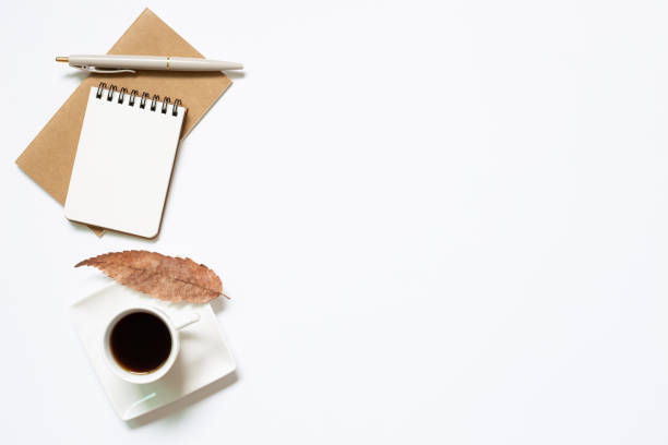 istock Notebook, pen, cup of coffee with leaves on white background. Work and study place. flat lay, top view, copy space 1254500425