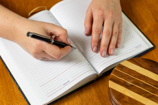 istock Hands of a woman writing in a notebook. 1254503570
