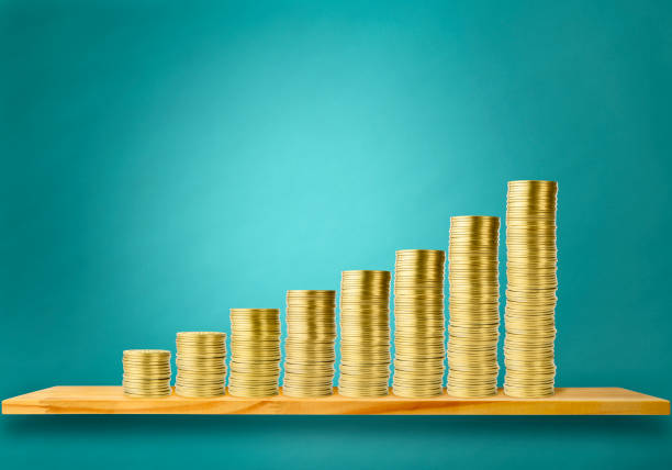 Stair-shaped gold coins chart on the shelf against light blue wall background.