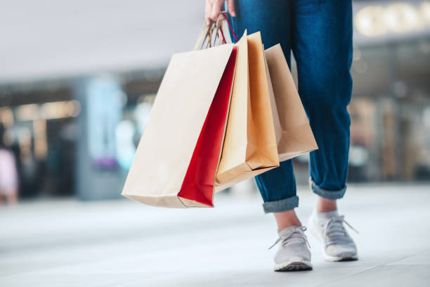 mulher segurando sacolas de compras de venda. consumismo, compras, conceito de estilo de vida - shopping mall - fotografias e filmes do acervo