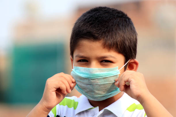 menino de 6 a 7 anos com máscara de poluição para proteção contra vírus - 6 7 years fotos - fotografias e filmes do acervo