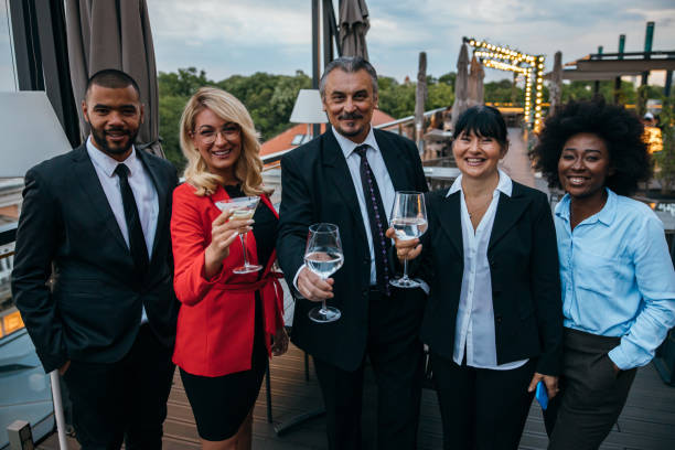 Portrait of smiling business people Group of multi-ethnic business people is looking at camera and smiling on the rooftop terrace. medium shot stock pictures, royalty-free photos & images