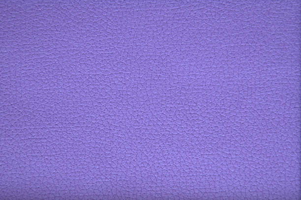 The texture of genuine leather of high-quality workmanship with small veins and folds, artificially painted in bright purple. Background.