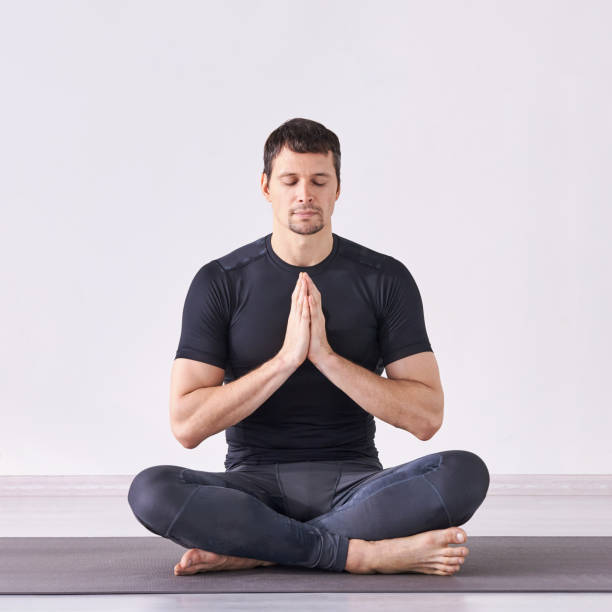 istock Man yoga class. Black wear. Calm relax pose 1254512674