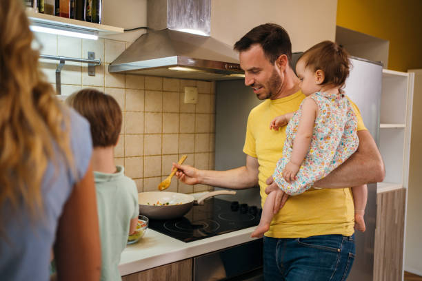 istock Father cooking with baby in arms 1254512847