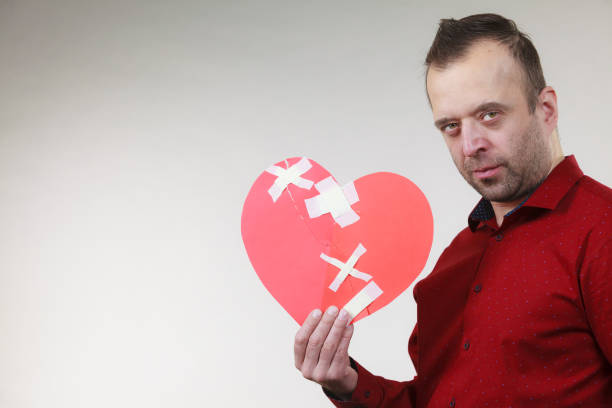 istock Sad adult man holding broken heart 1254515137