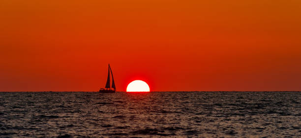 istock Sailboat Sunset Silhouette Panorama 1254515672