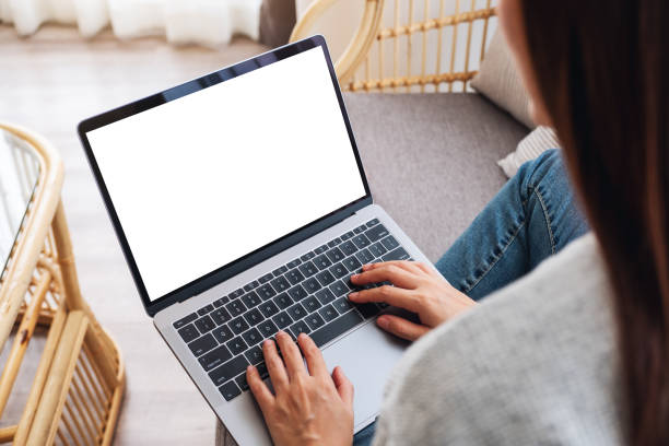 istock a woman working and typing on laptop computer with blank screen while sitting on a sofa at home 1254515711
