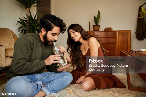 Smiling Young Couple Smoking A Bong Stock Photo - Download Image Now - Bong, Cannabis - Narcotic, 20-29 Years
