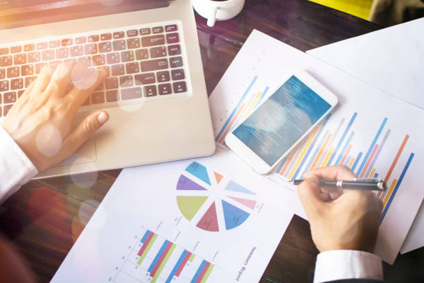 istock business hand working on laptop computer with financial business graph information diagram on wooden desk as concept 1254517609