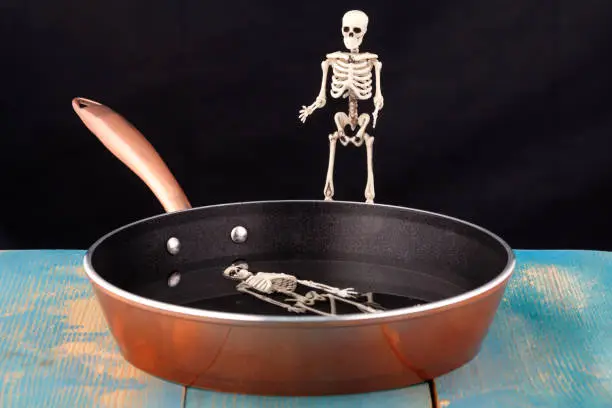 Photo of there's a human skeleton in the pan, and another skeleton above it